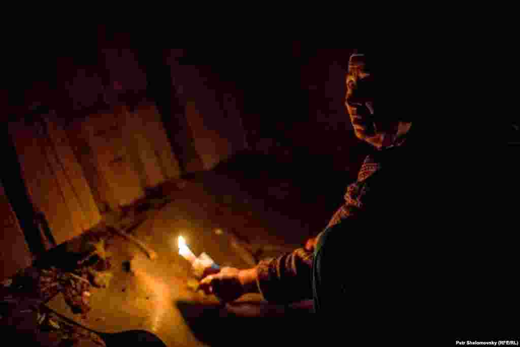 Женщина показывает неразорвавшийся снаряд, застрявший в полу ее дома. Дебальцево 