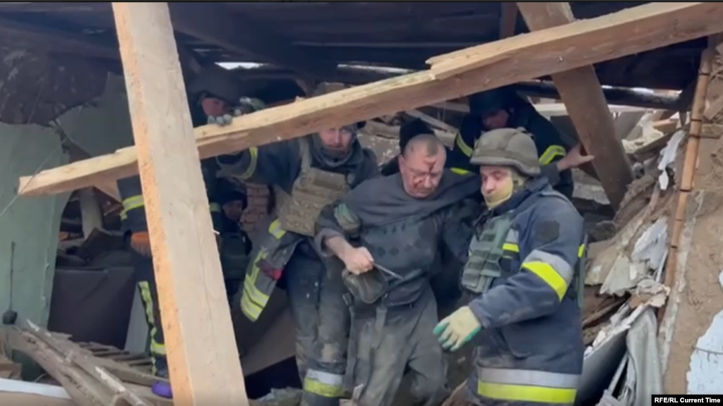 Сотрудники ГосЧС Украины эвакуируют пострадавших из-под завалов дома в Змиеве Харьковской области после ракетного удара войск РФ, 8 января 2024 года 