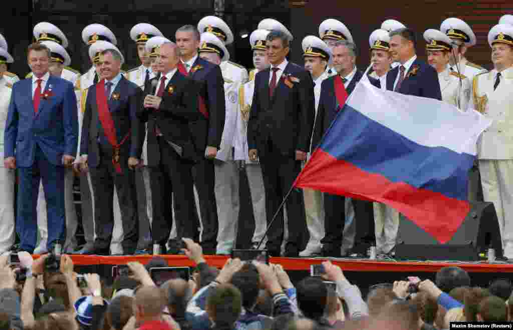 В 2014 году 9 мая после парада в Москве Владимир Путин поехал в аннексированный Севастополь – впервые после оккупации Крыма в марте этого года. На фото рядом с ним – назначенные Россией чиновники: так называемый спикер парламента Крыма Владимир Константинов, так называемый премьер-министр Сергей Аксенов и другие 