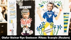 Баннер с изображением президента России Владимира Путина и президента Украины Владимира Зеленского во время демонстрации против вторжения России в Украину перед датским парламентом во дворце Кристиансборг в Копенгагене, Дания, 5 марта 2022 года