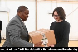 На этой фотографии, опубликованной на странице президента ЦАР в фейсбуке, Дмитрий Сытый (справа) передает коробки с медицинскими принадлежностями президенту Фостену-Арканжу Туадере в феврале 2025 года