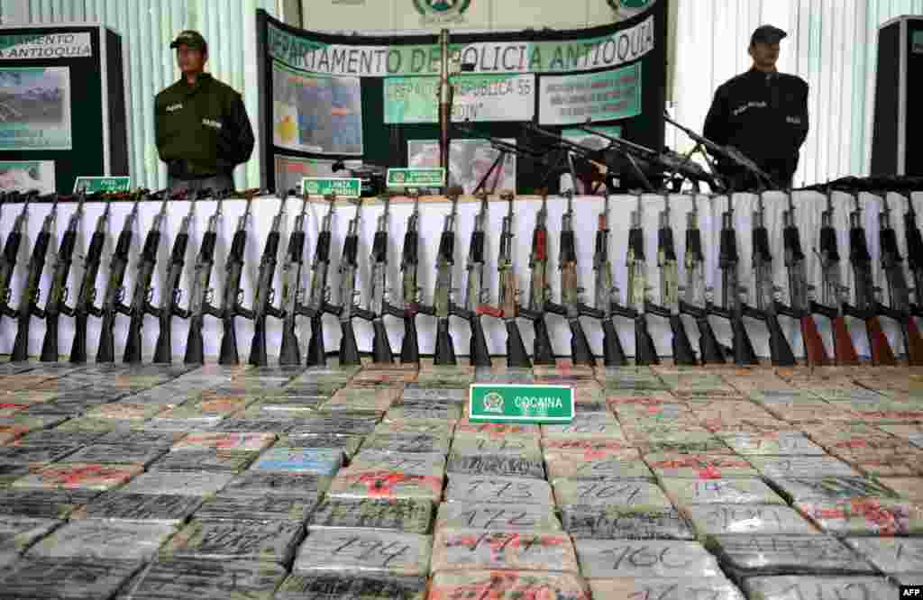 Эквадор и Перу уже много лет нелегального поставляют оружие колумбийским наркокартелям. По данным американского стратегического исследовательского центра RAND, частные охранные предприятия и граждане, замешанные в криминале, перепродают оружие с военных складов на международном черном рынке. Позже товар доставляют через горные маршруты, сплавляют по реке или перевозят по специальным партизанским маршрутам в джунглях, чтобы правительственные службы не смогли помешать сделке На фото – оружие (98 штук АК-47) и брикеты с кокаином, конфискованные у колумбийских наркокартелей, в полицейском участке. Сентябрь 2008 года
