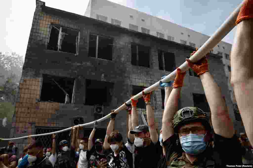 Рабочие помогают разбирать завалы разрушенной детской больницы, 8 июля 2024 года, фото Reuters