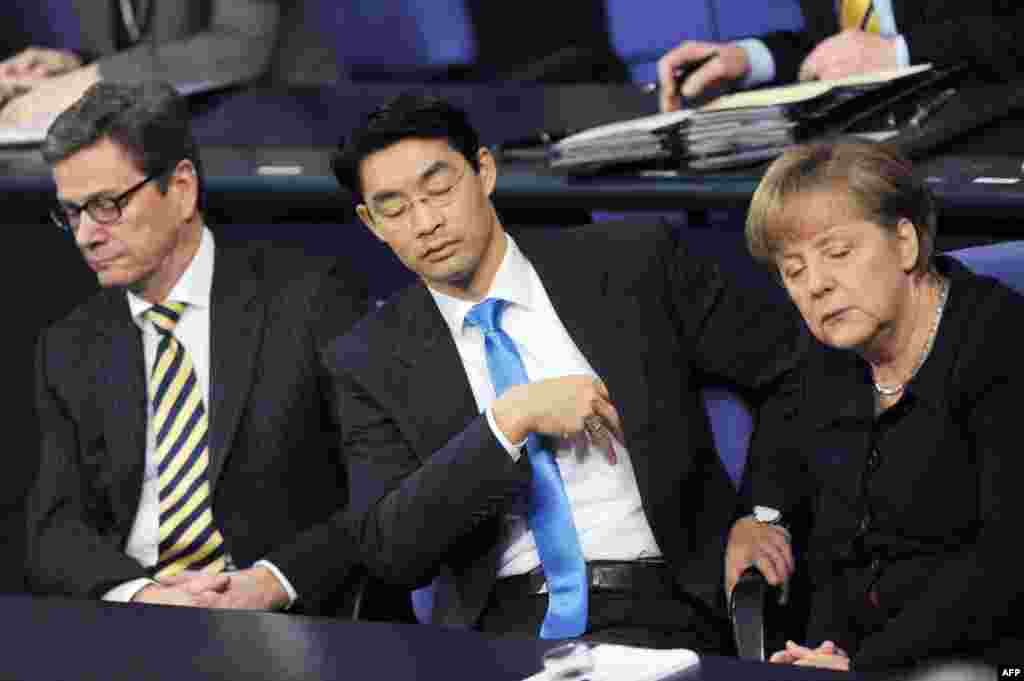 Канцлер Германии Ангела Меркель (справа), министр экономики Филипп Реслер (в центре) и бывший министр иностранных дел Гидо Вестервелле (слева) утомились на одном из заседаний в Бундестаге 