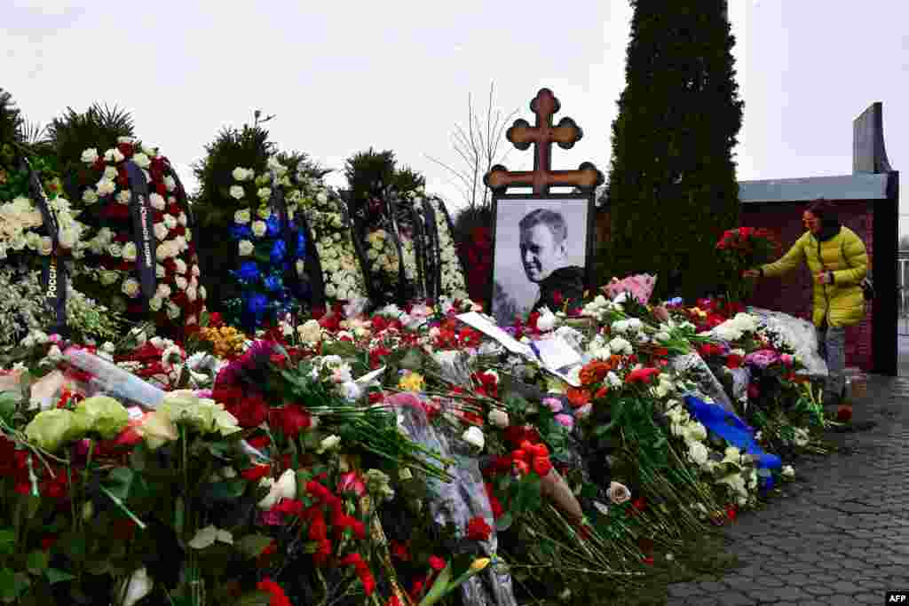 Люди кладут цветы к могиле Алексея Навального