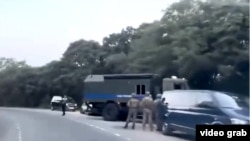 Скриншот видео на дороге около воинской части в Щитовой, где видны машины силовиков