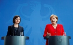 Санду во время своего премьерства на встрече с канцлером Германии Ангелой Меркель