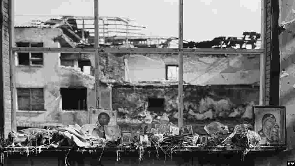 Иконы, цветы, бутылки с водой, еда и свечи на окнах спортзала. Школа №1, Беслан, Северная Осетия. 17 сентября 2004. Джеймс Хилл 