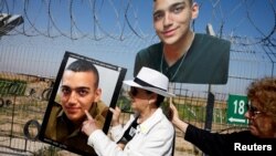 Фотография похищенного Идена Александера в руках его бабушки во время акции, организованной родственниками заложников. Апрель 2025 года