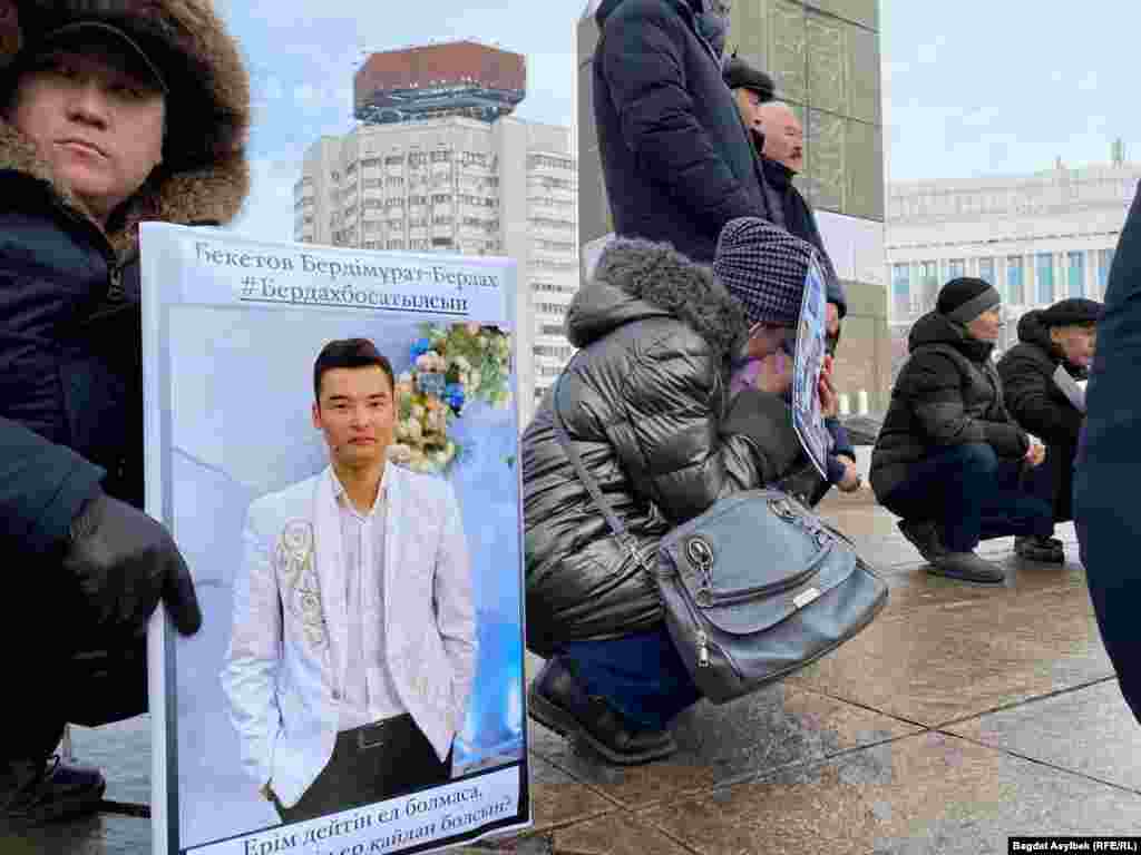 В руках – фотографии погибших и подвергшихся пыткам после задержания