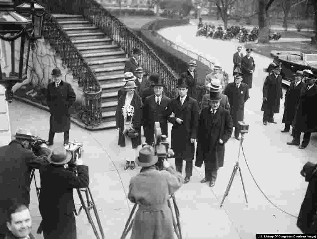 Недавно вступивший в должность президент Франклин Делано Рузвельт (в центре в полосатом галстуке) прибывает в Белый дом со своей женой Элеонорой и сыном Джеймсом 4 марта 1933 года. Президент будет служить беспрецедентные четыре срока – с 1933-го по 1945 год. Поправка к Конституции 1951 года сократила количество возможных президентских сроков до двух