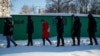 RUSSIA - Law enforcement officers walk behind people near a court building during a hearing to consider the case of Russian opposition leader Alexei Navalny, who is accused of flouting the terms of a suspended sentence for embezzlement, in Moscow, Russia